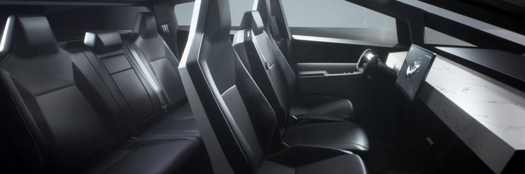 Sleek, futuristic vehicle interior with three rows of angular seats, steering wheel, and a large touchscreen on the dashboard. Minimalist, modern design.