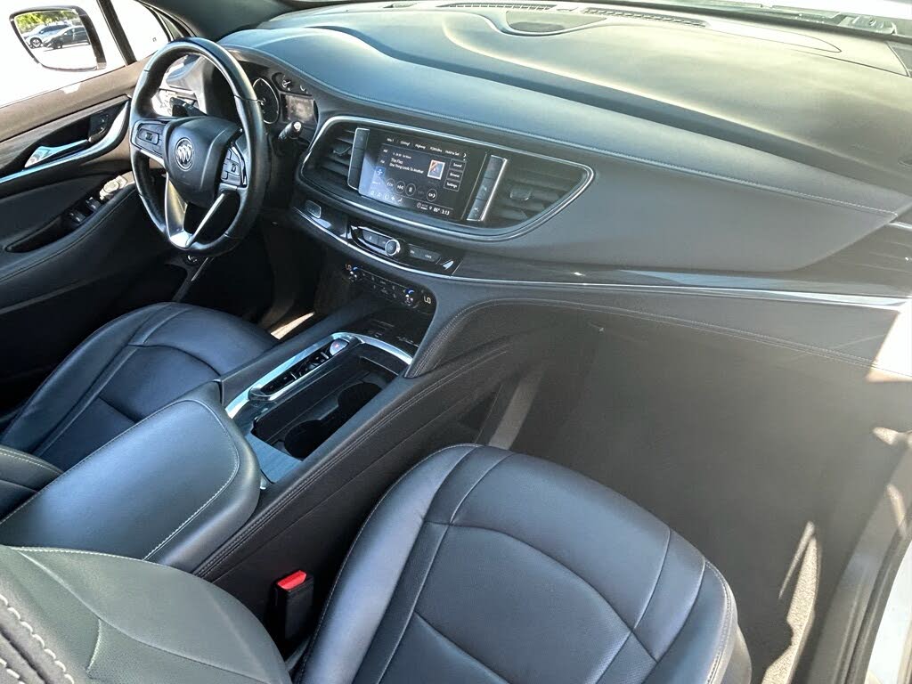 12 Interior of a modern car with black leather front seats, a steering wheel, and a dashboard touchscreen.