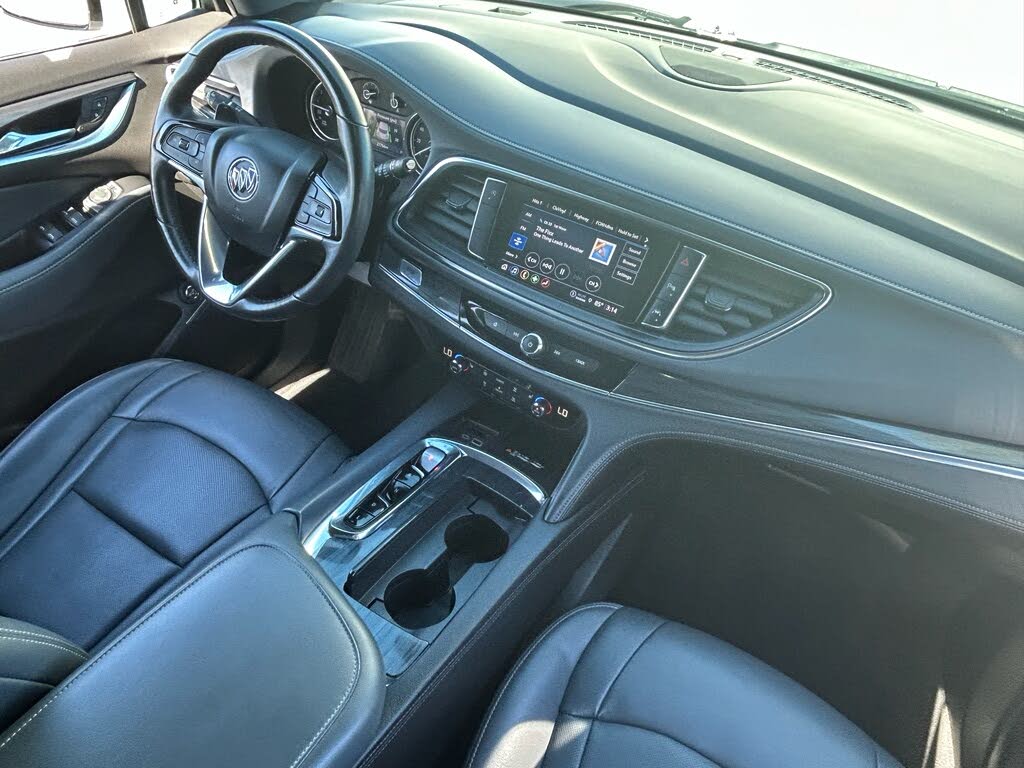14 Interior of a modern car with black leather seats, a steering wheel, and a center touchscreen display.