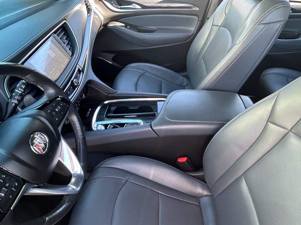 21 Gray leather interior of a Cadillac, featuring the front seats, steering wheel with the Cadillac emblem, and center console.