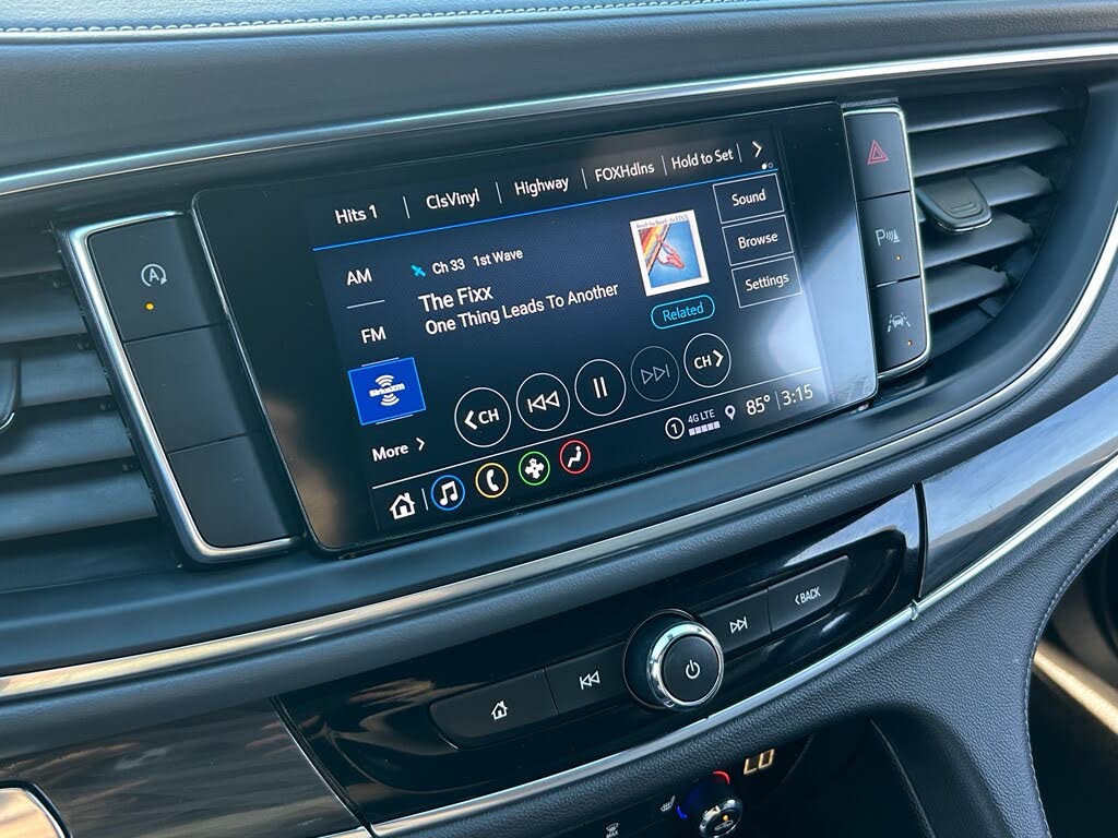 25 Close-up of a car's dashboard with a touchscreen displaying a music player interface.