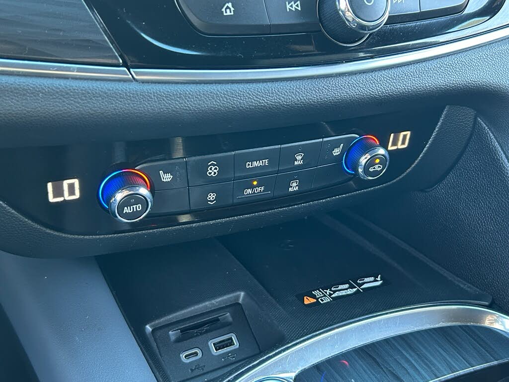26 Close-up of a car's center console with dual-zone climate controls set to LO, USB ports, and an SRT badge.