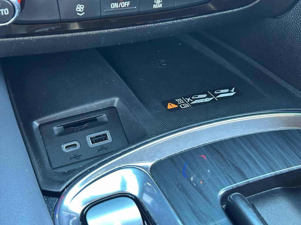 27 Close-up of a car's center console with a dual USB port panel and a small warning sticker.