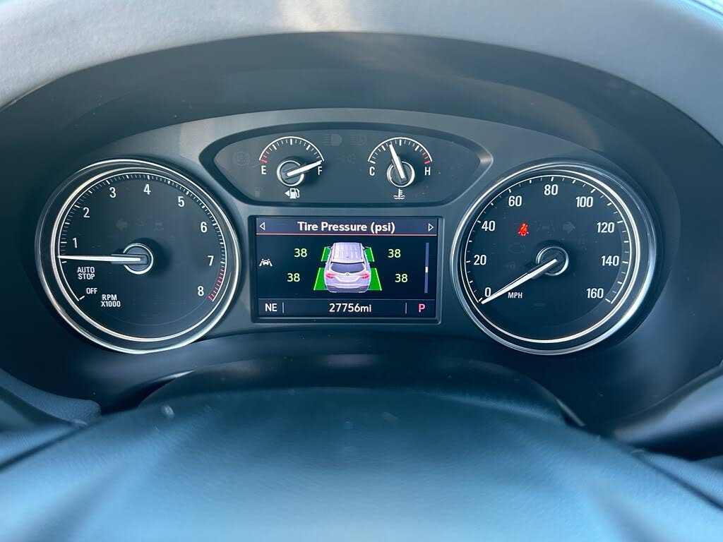 29 Dashboard instrument cluster with analog gauges on the sides and a central digital screen showing tire-pressure information.