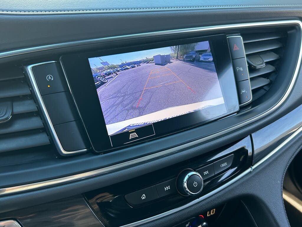 30 Infotainment screen shows the rear-view camera feed of a parking lot behind the vehicle.