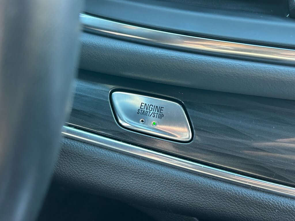 32 Chrome engine start/stop button on a car dashboard.